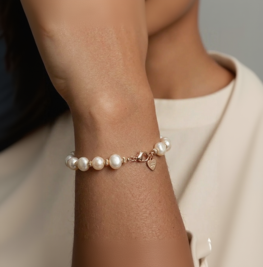 Pearl bracelet on a wrist with a neutral background