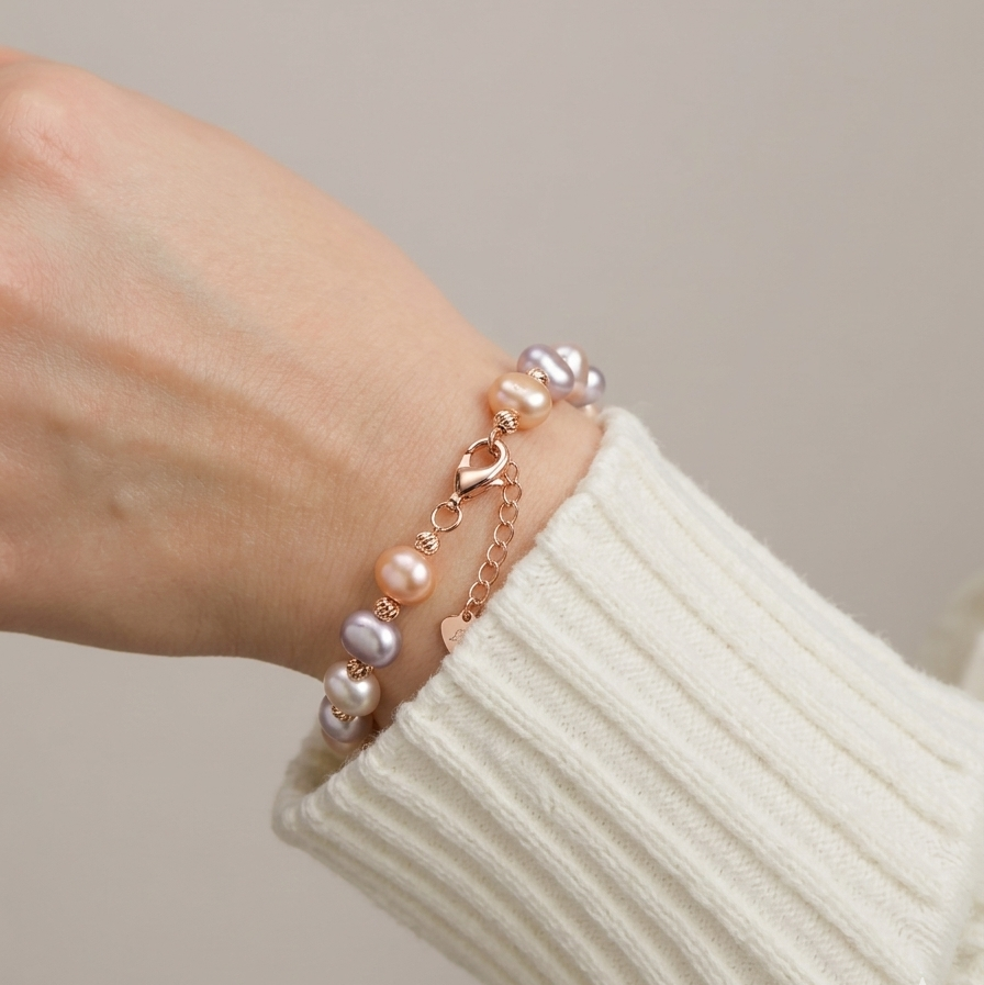Pearl bracelet on a wrist with a neutral background
