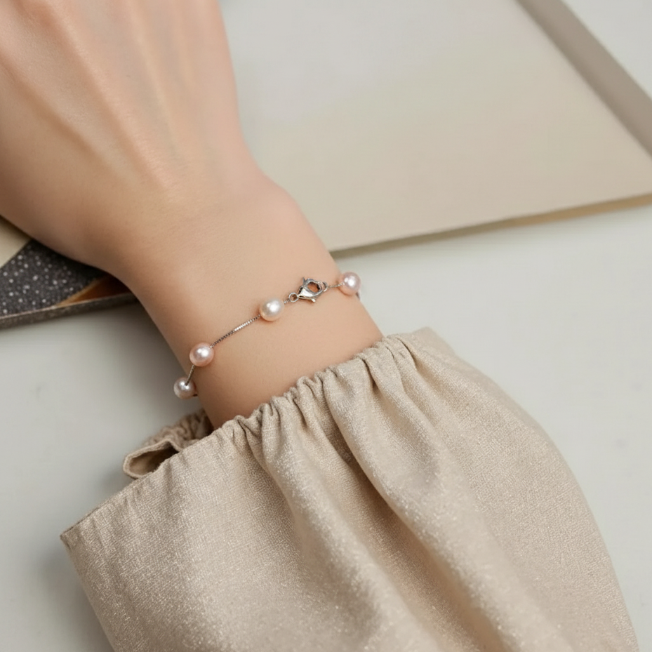 Pearl bracelet on a wrist with a neutral background