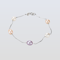 Pearl bracelet with pink and purple pearls on a light gray background