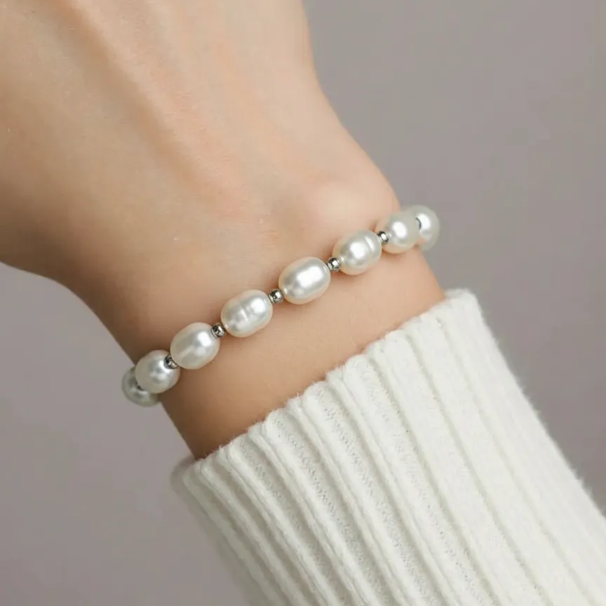 Pearl bracelet on a wrist with a neutral background
