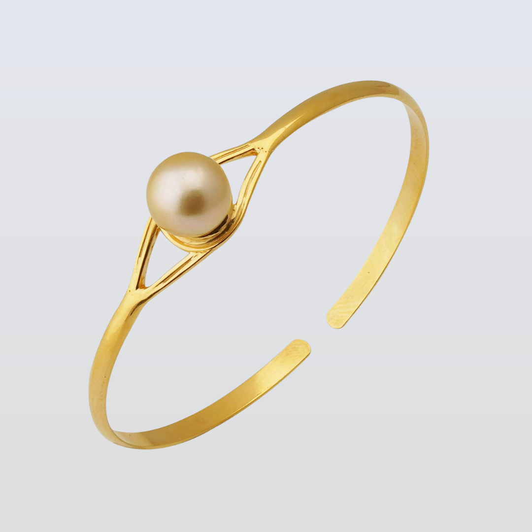 Gold bracelet with a pearl on a light gray background