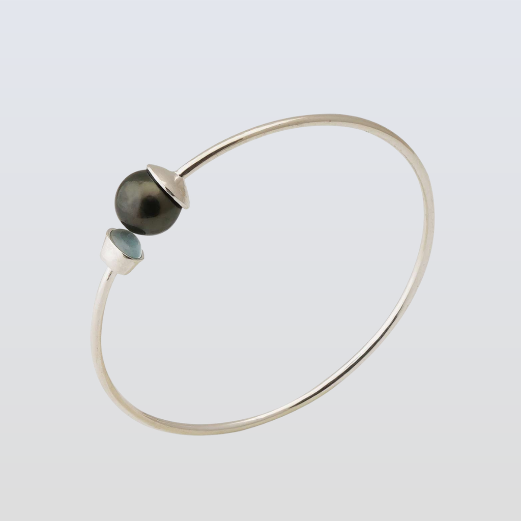 Silver bracelet with two beads on a light gray background