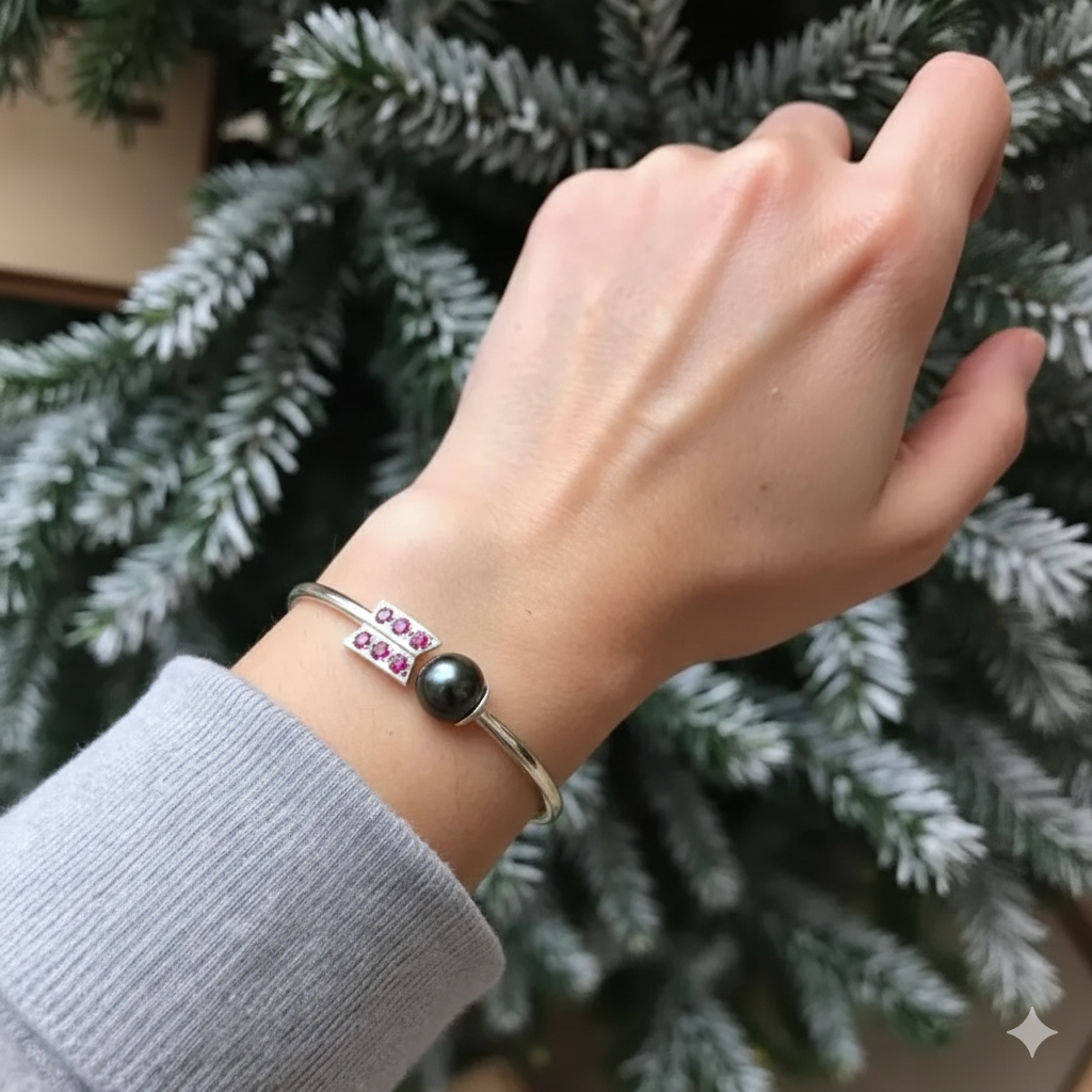 Hand wearing a bracelet with a black bead against a green foliage background