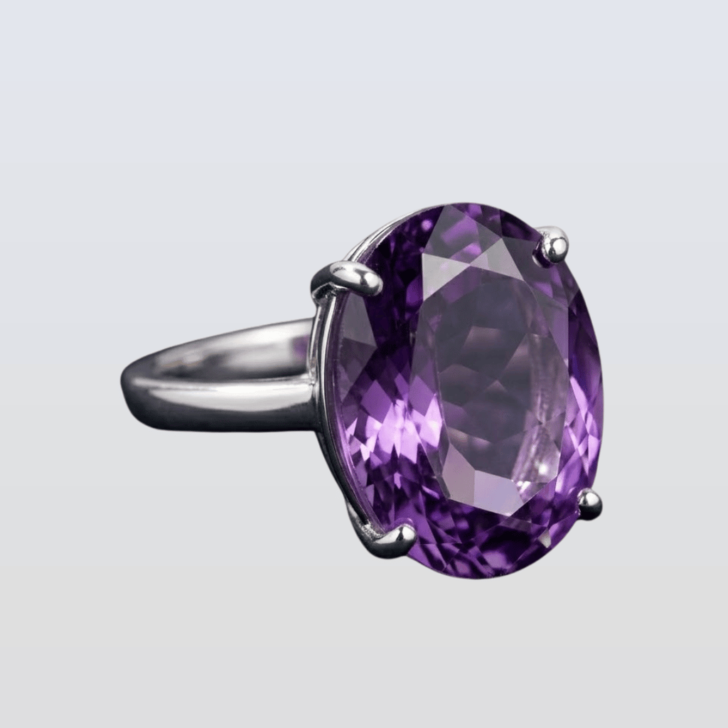 Silver ring with a large purple gemstone on a light gray background