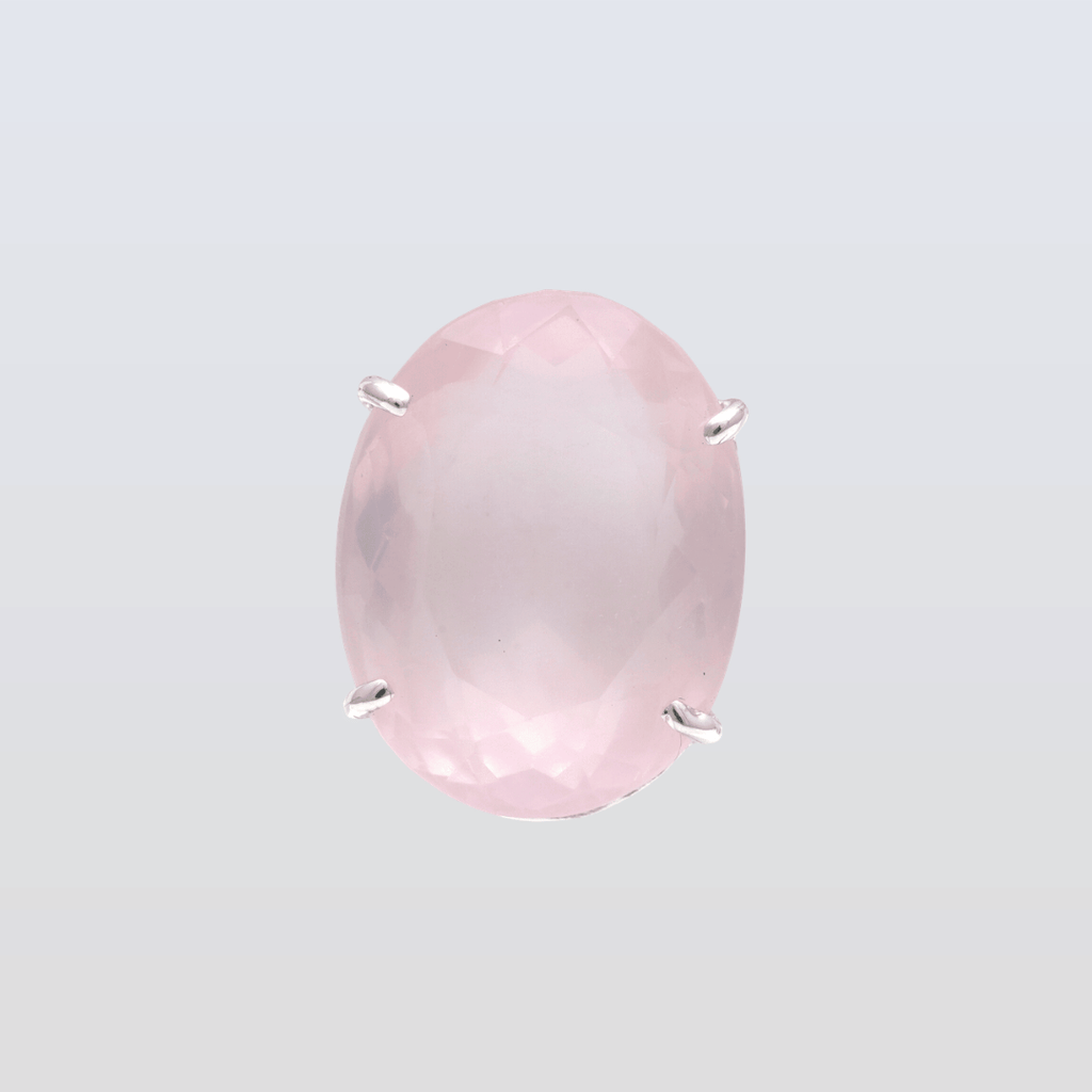 Pink gemstone with silver prongs on a light gray background
