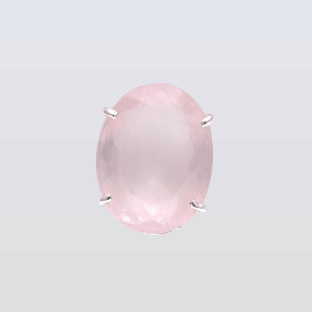 Pink gemstone with silver prongs on a light gray background