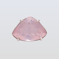 Pink gemstone ring with silver prongs on a light gray background