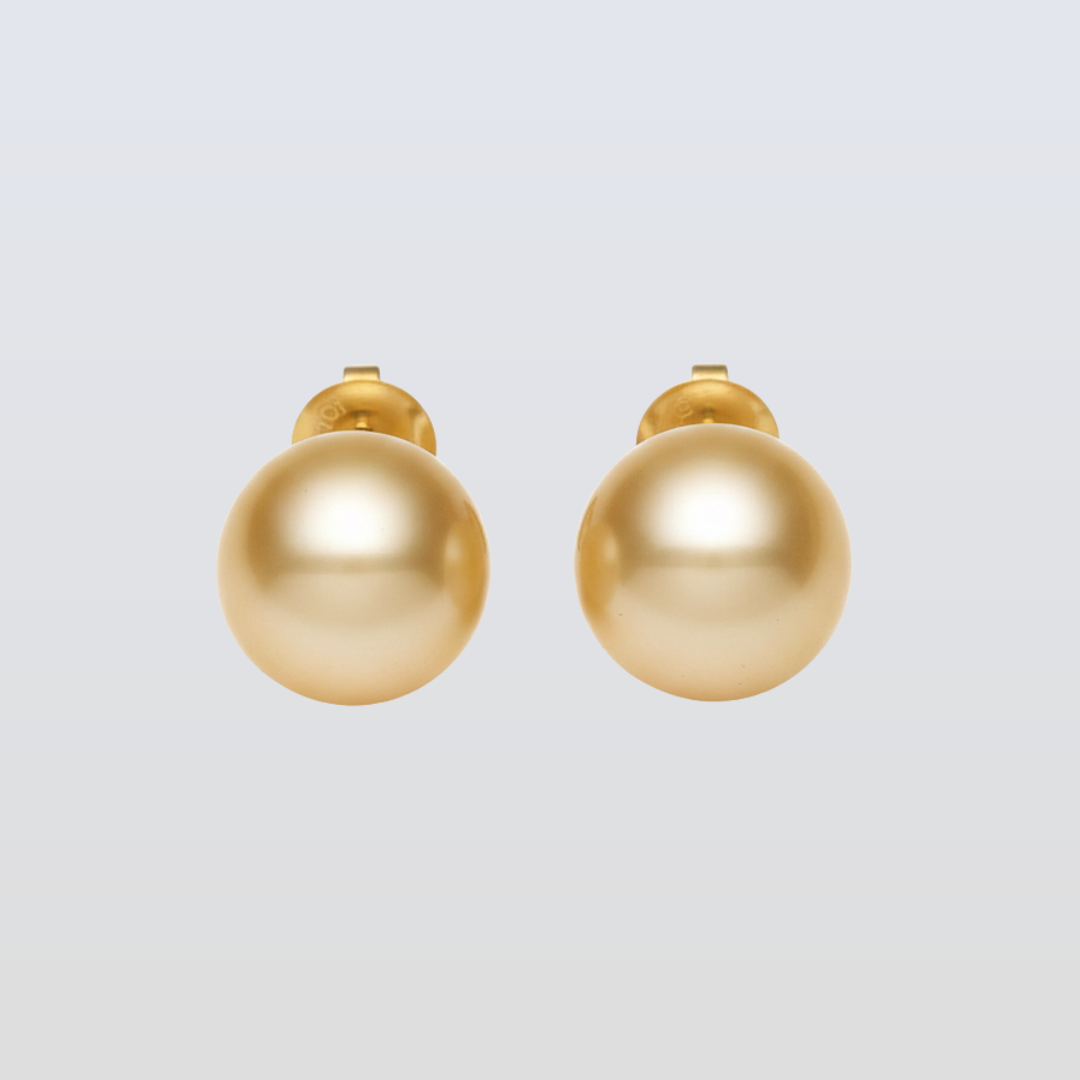 Pair of gold spherical earrings on a light gray background