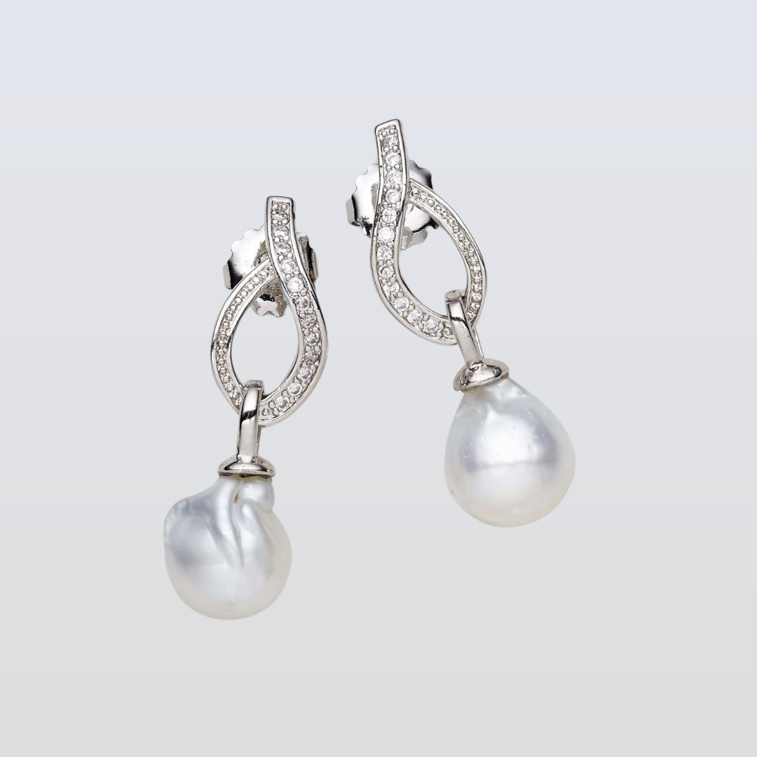 Pearl earrings with silver fixtures on a light gray background