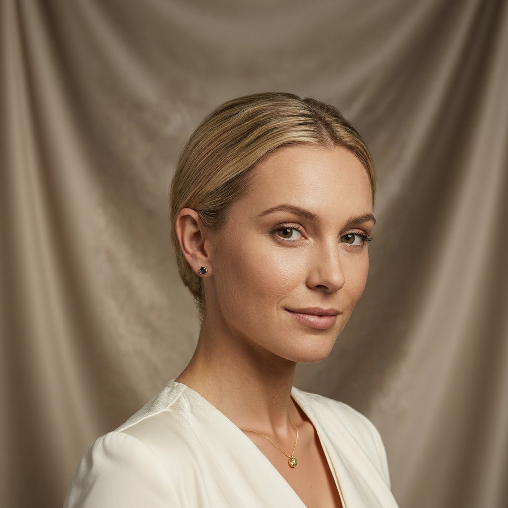 Woman with blonde hair and earrings against a neutral background