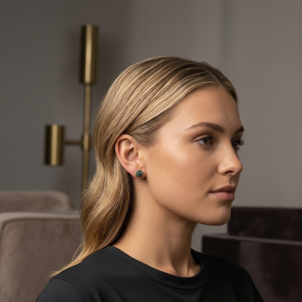 Close-up of a woman wearing green earrings with a blurred background