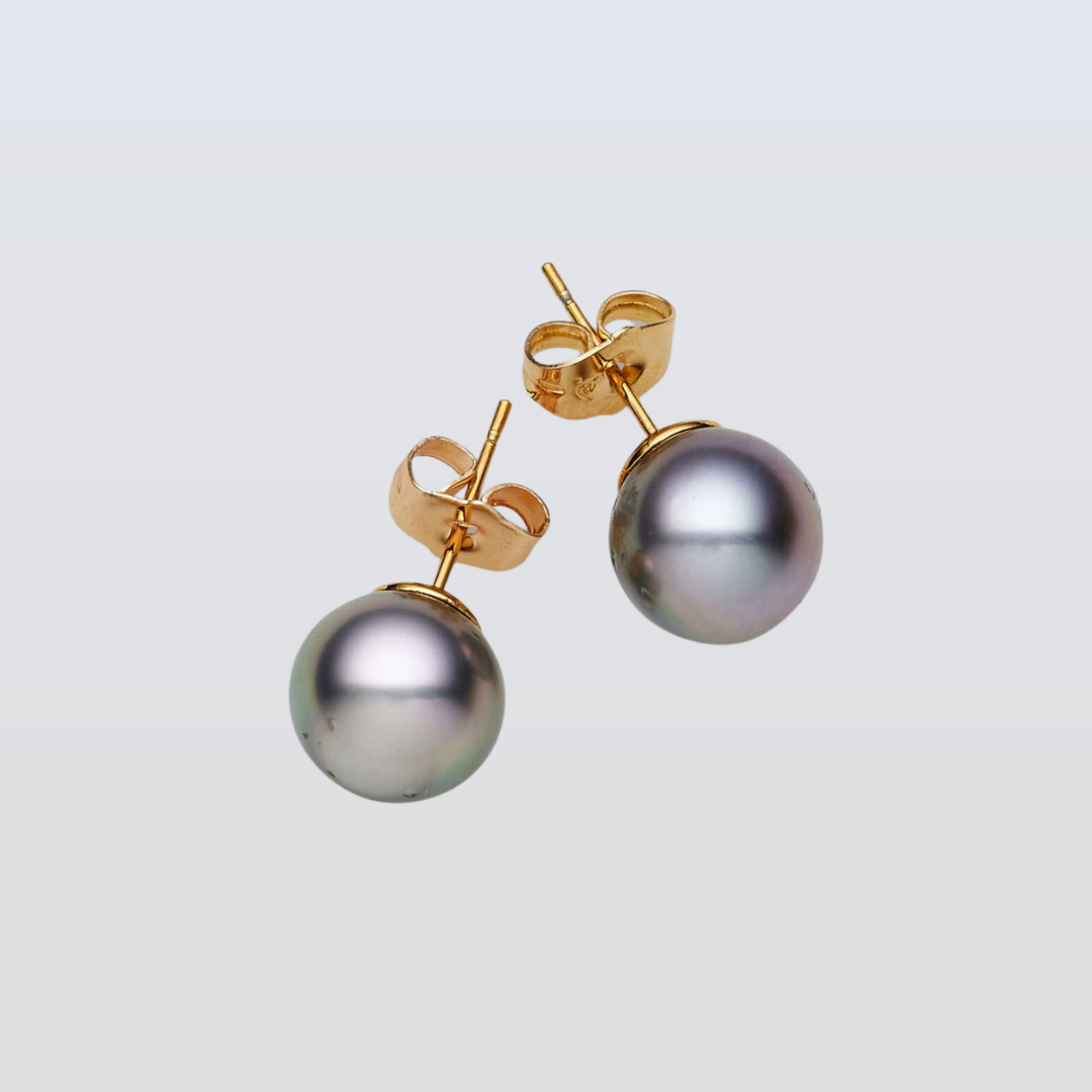 Pair of pearl earrings with gold posts on a light gray background