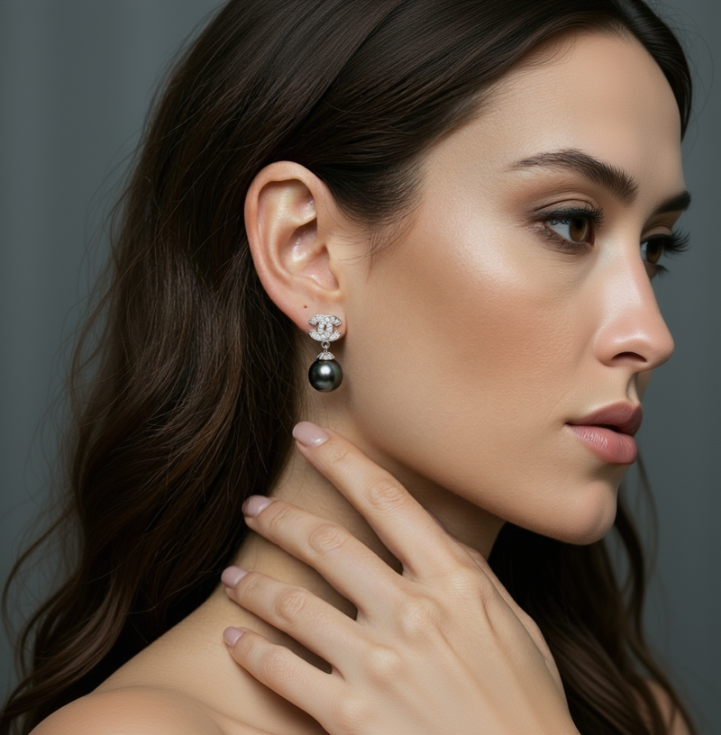 Close-up of a woman wearing a black pearl earring with a diamond clasp.