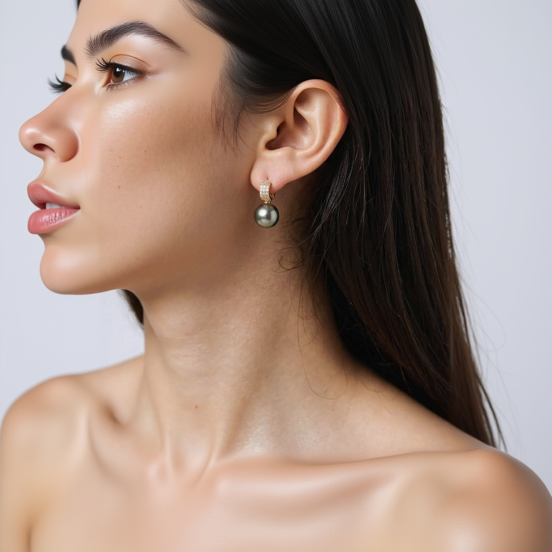Close-up of a person wearing pearl earrings with a neutral background
