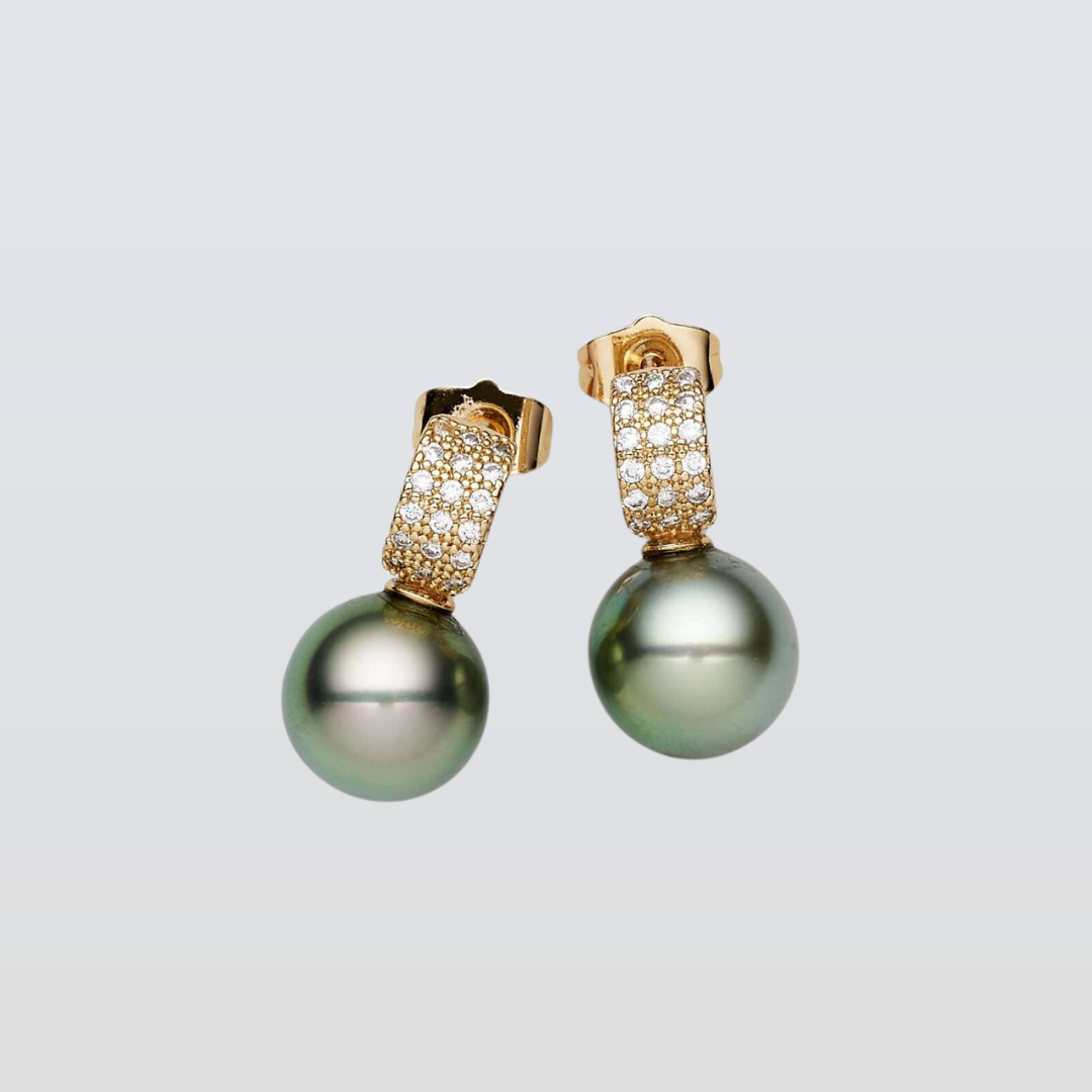 Pair of pearl earrings with gold and diamond accents on a light gray background
