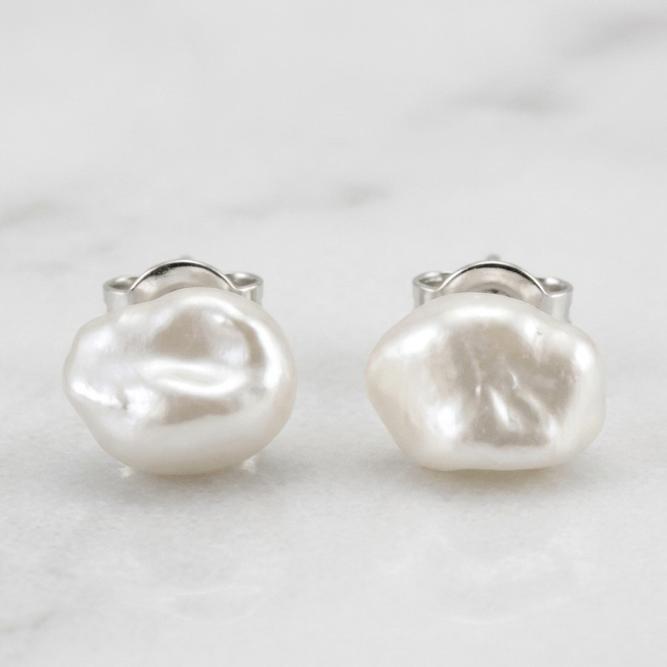 Pair of pearl earrings on a light gray background