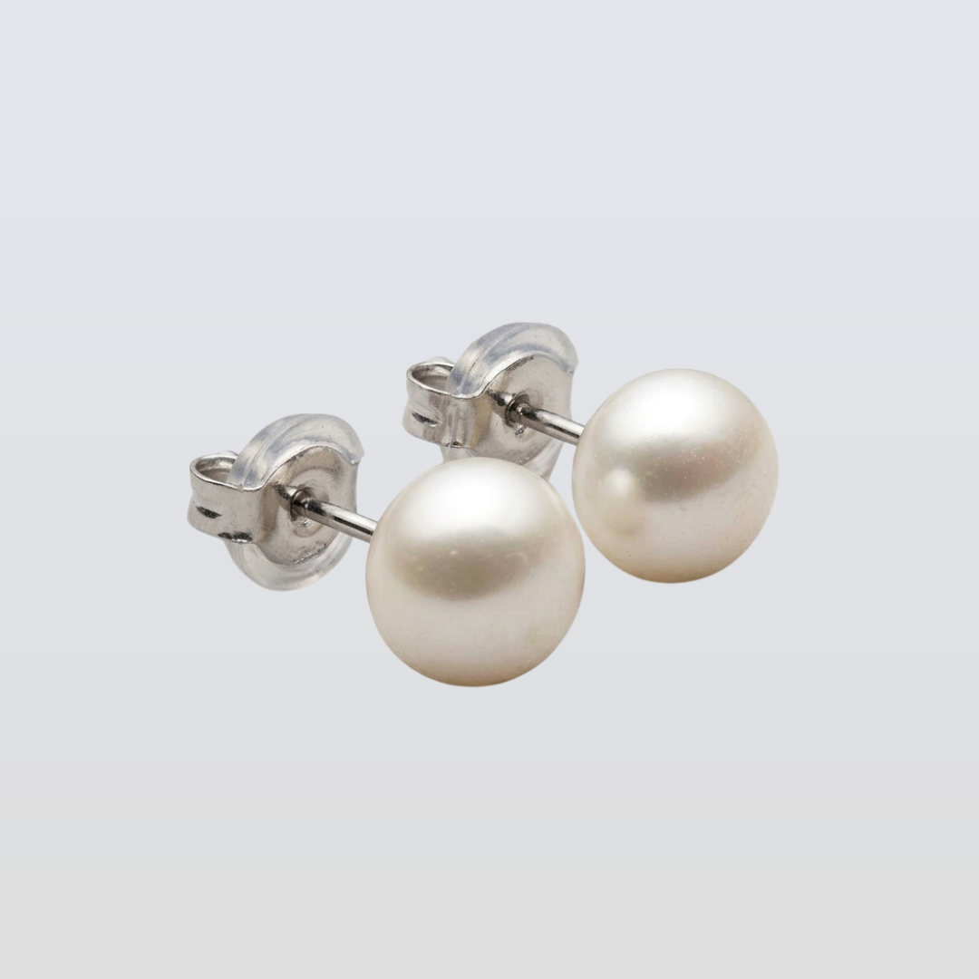 Pearl stud earrings on a light gray background