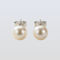 Pair of pearl earrings on a light gray background