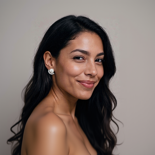 Woman wearing a pearl earring against a neutral background