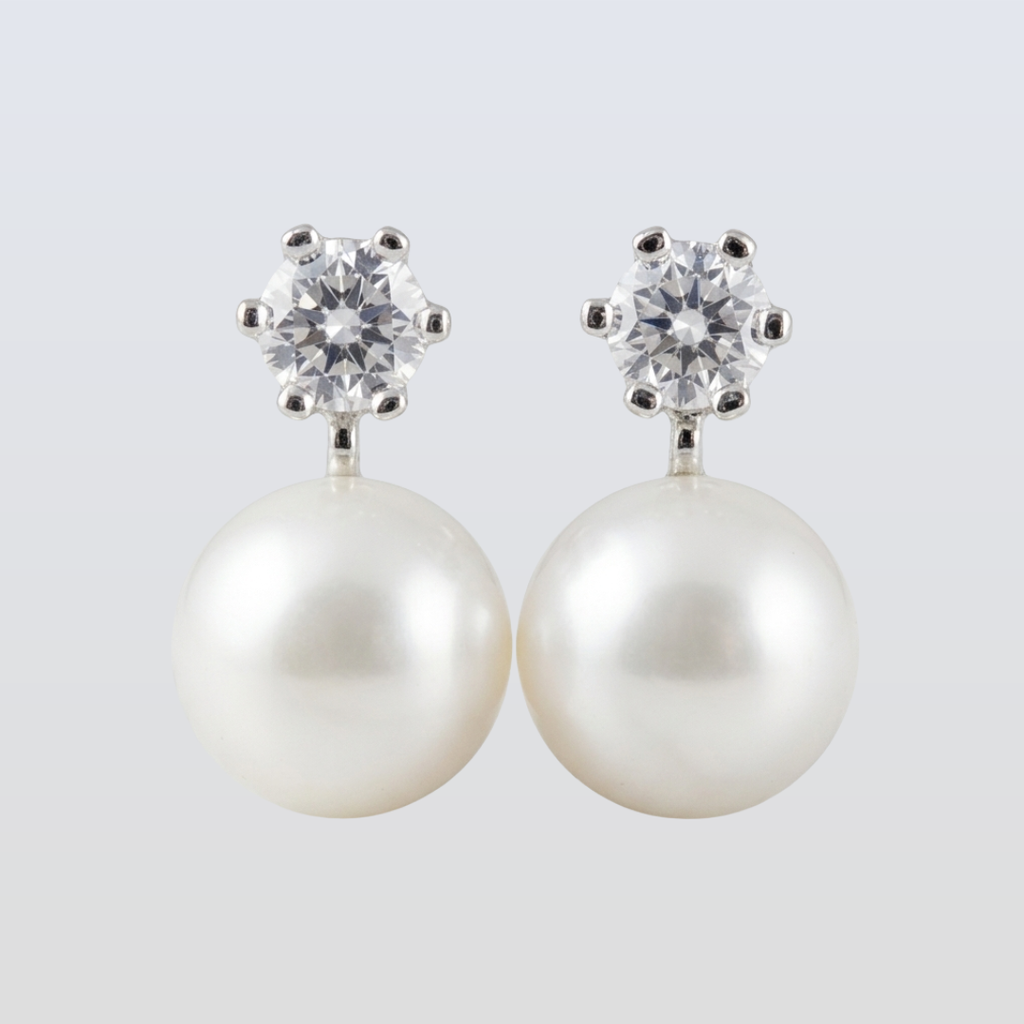 Pearl earrings with crystal tops on a light gray background
