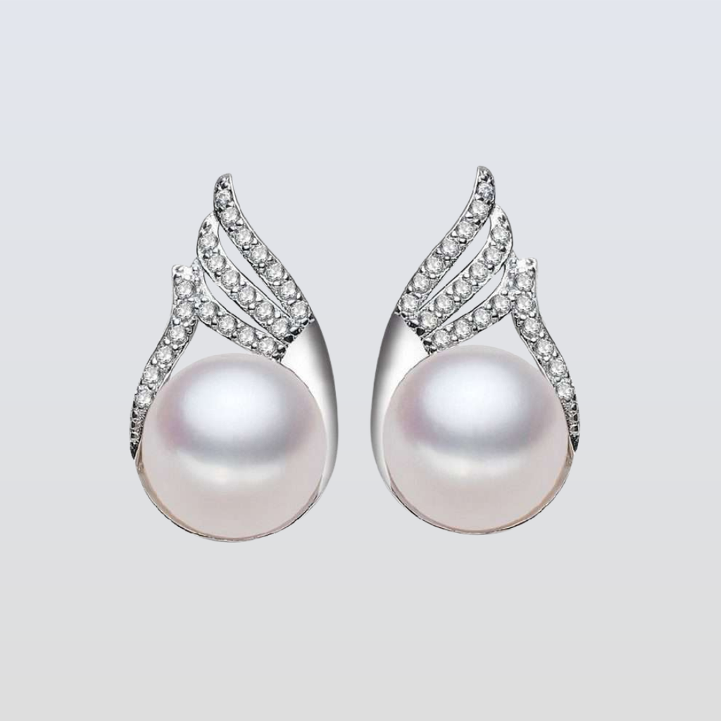 Pearl earrings with silver and diamond accents on a light gray background