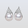Pearl earrings with silver and diamond accents on a light gray background