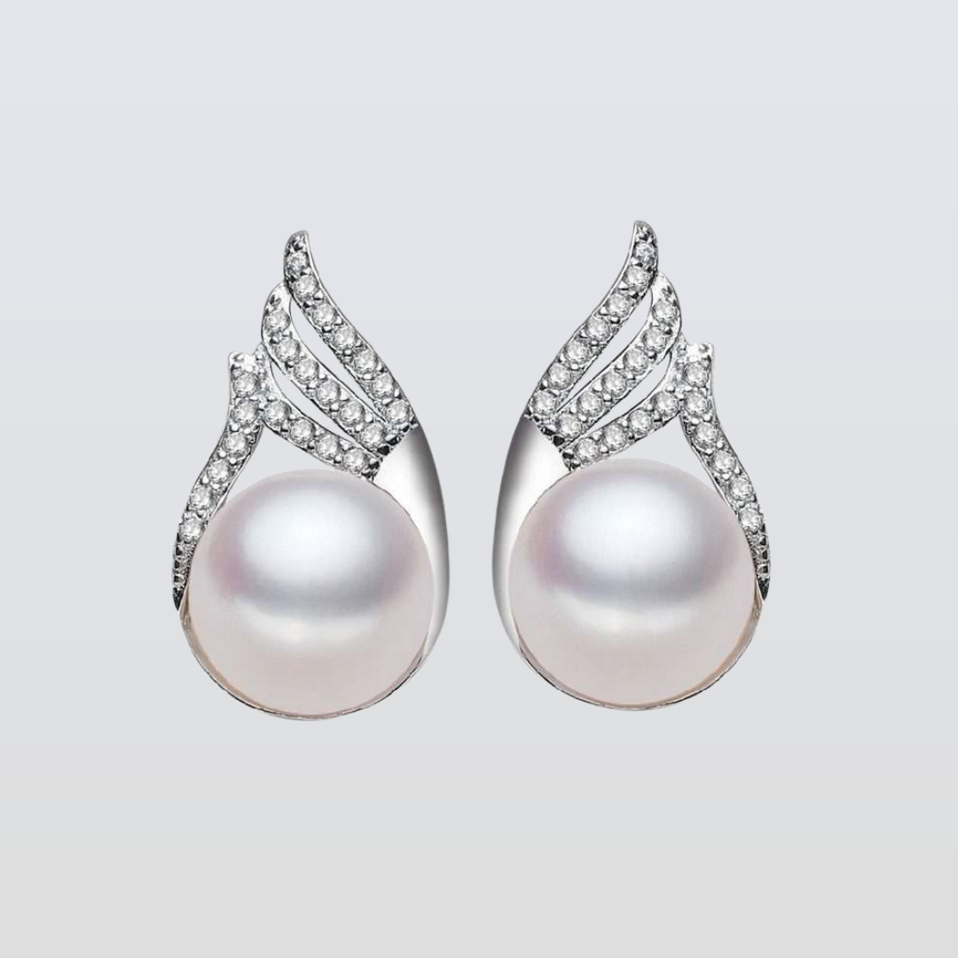 Pearl earrings with silver and diamond accents on a light gray background