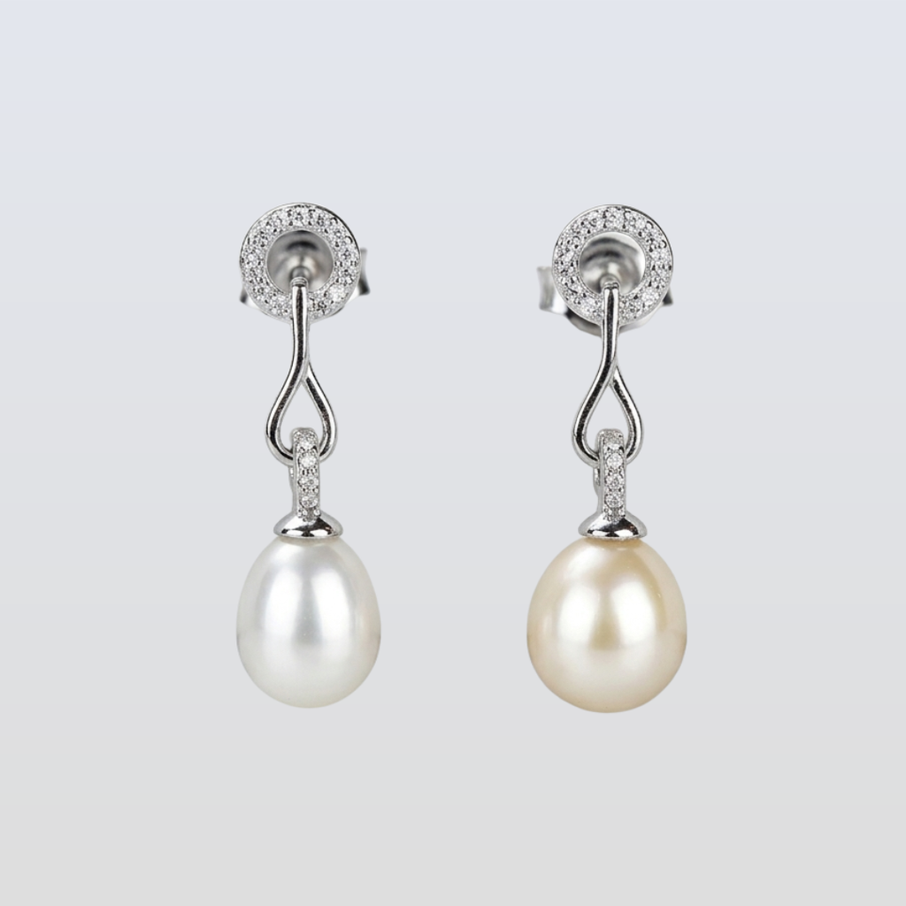 Pearl earrings with silver fixtures on a light gray background
