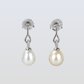 Pearl earrings with silver fixtures on a light gray background