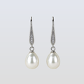 Pearl earrings with silver hooks on a light gray background