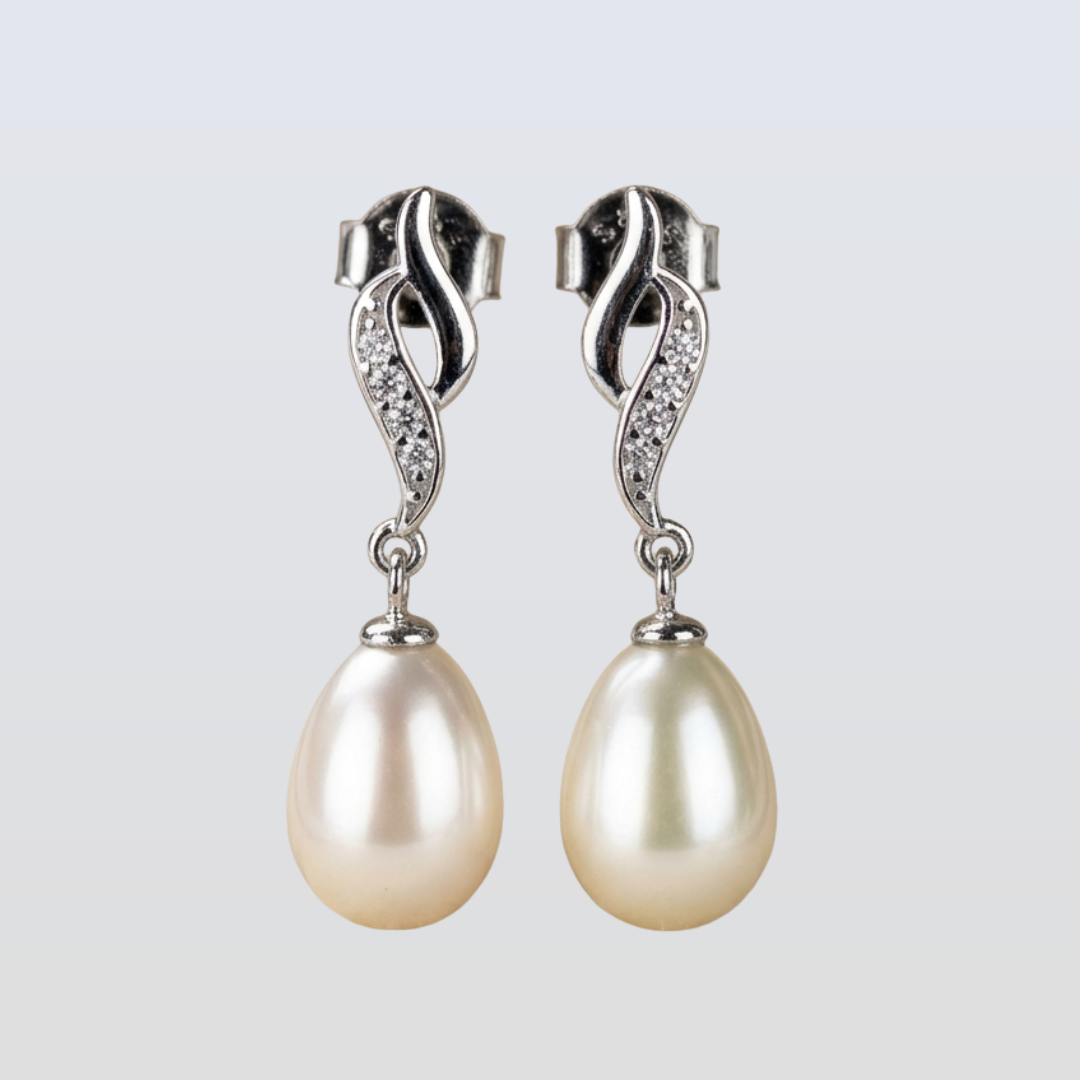 Pair of pearl earrings with silver clasps on a light gray background