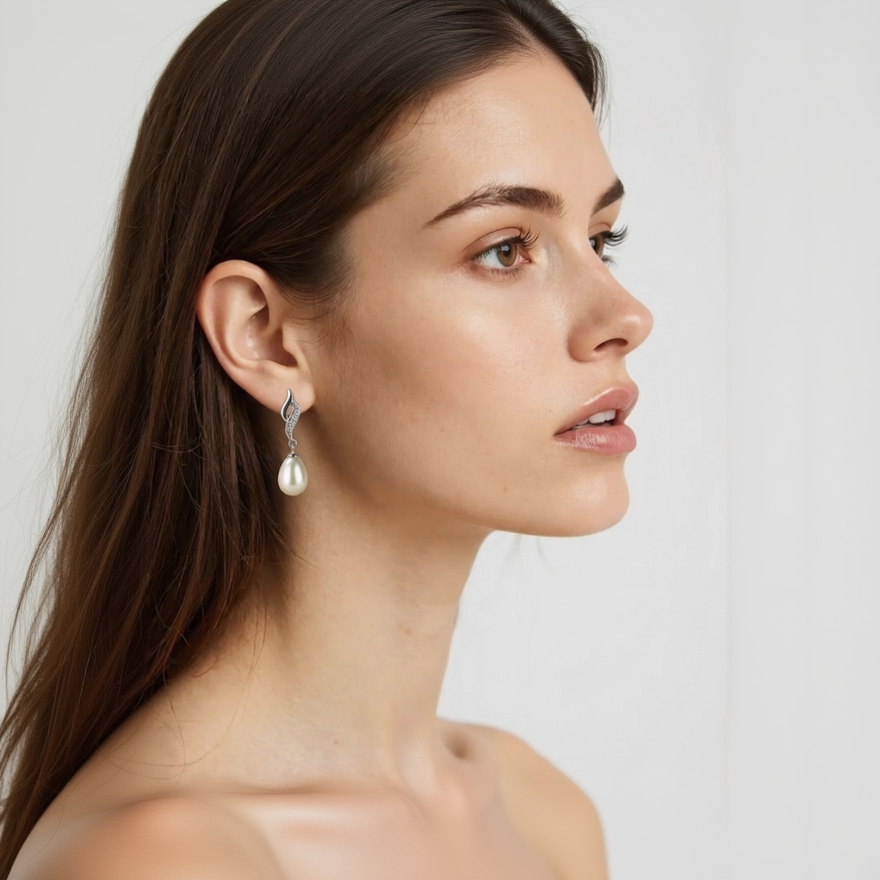 Close-up of a woman wearing a pearl earring with a plain background