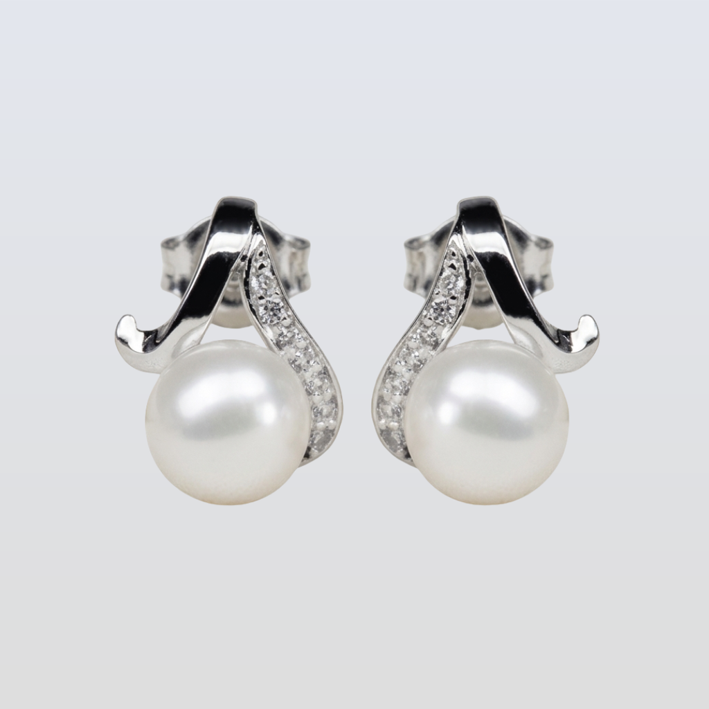 Pearl earrings with silver and diamond accents on a light gray background