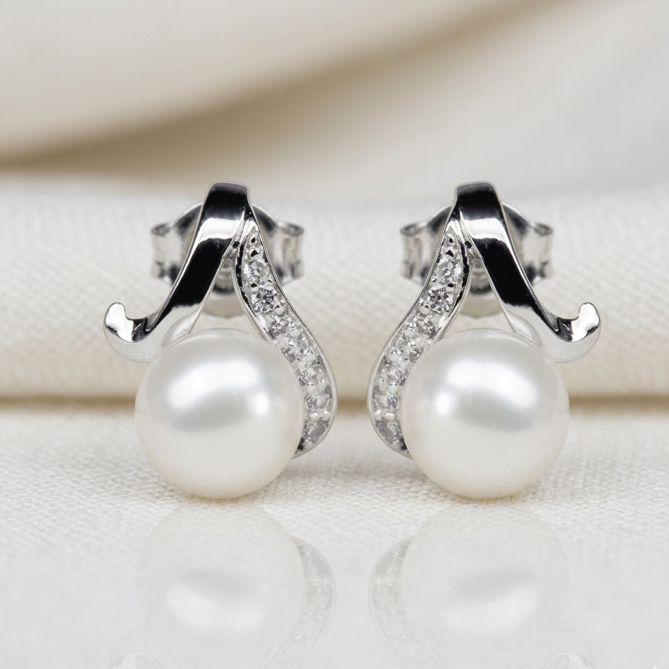 Pearl earrings with silver fixtures on a textured surface