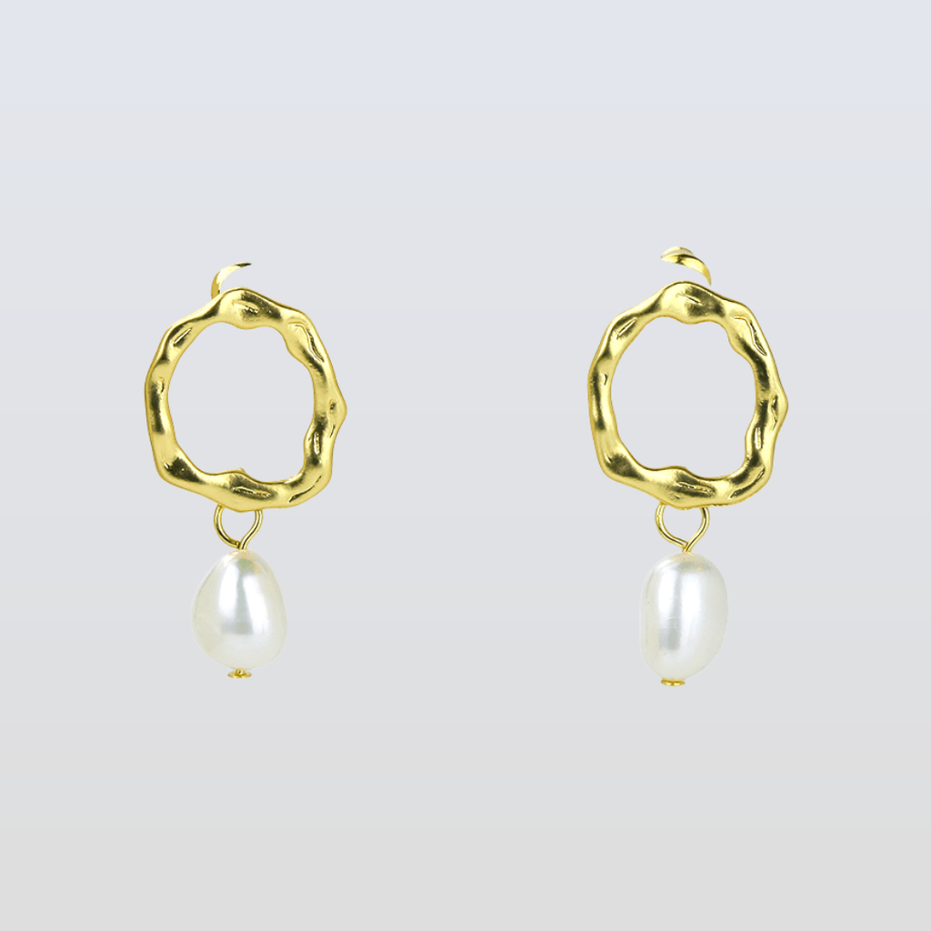 Gold hoop earrings with pearl drops on a light gray background
