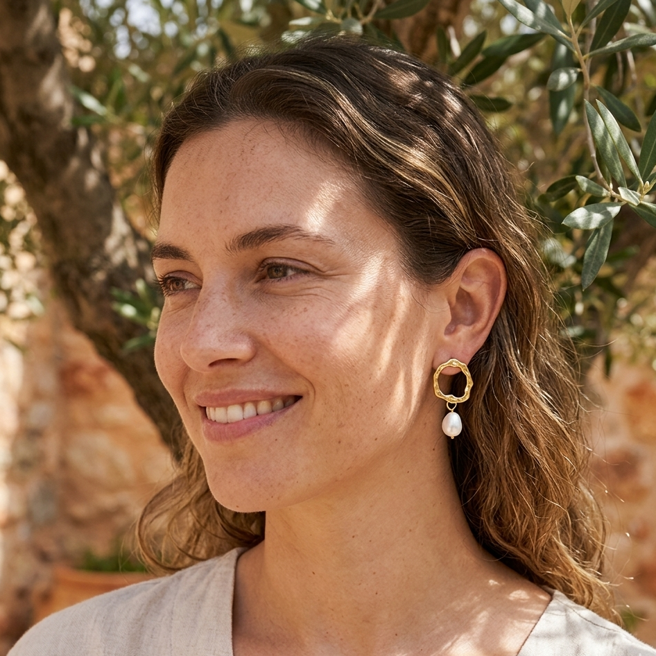 Woman wearing gold hoop earrings with a natural background