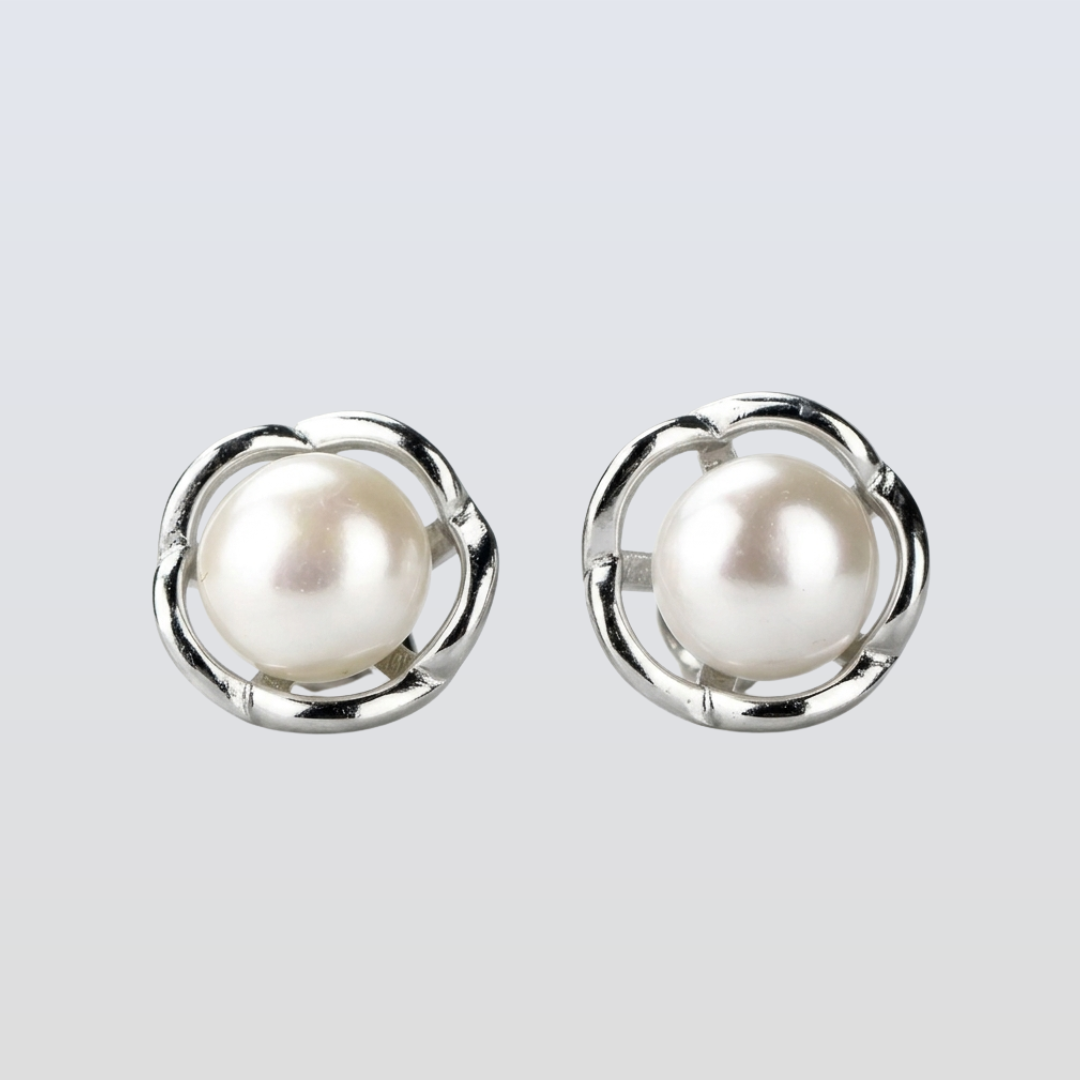 Pearl earrings with silver circular frames on a light gray background