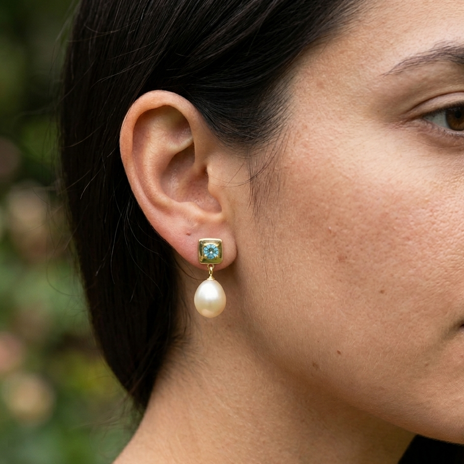 Close-up of a woman wearing a pearl earring with a blurred natural background