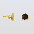Gold earrings with a dark stone on a light gray background