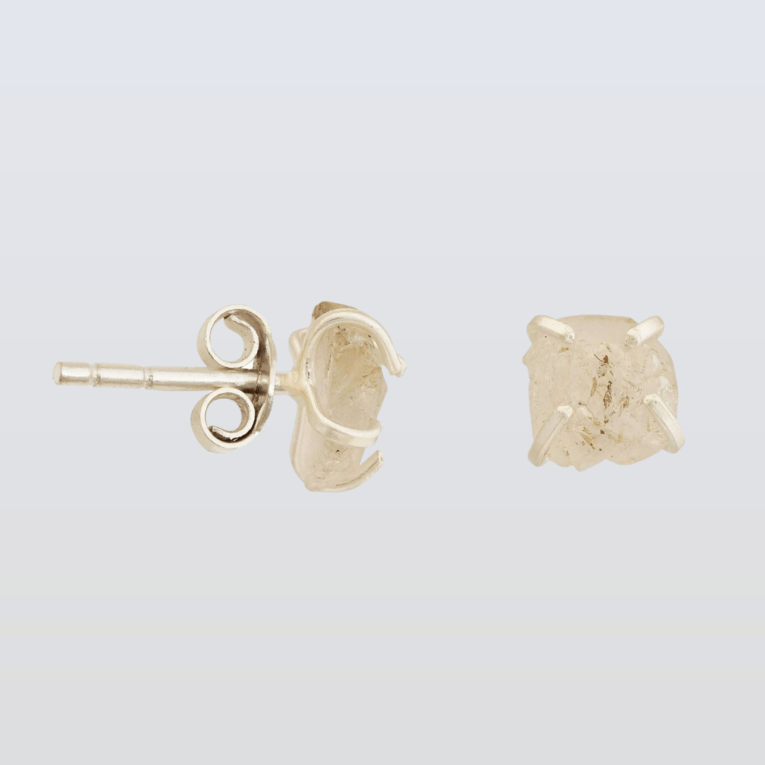 Gold stud earrings on a light gray background