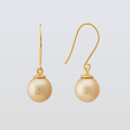 Gold earrings with pearl drops on a light gray background