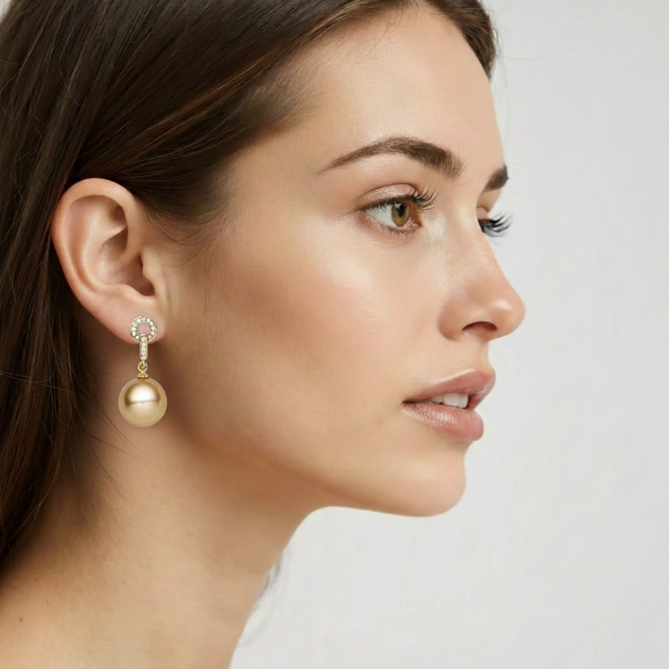 Woman wearing gold earrings on a plain background