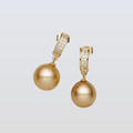 Gold pearl earrings with gold hooks on a light gray background