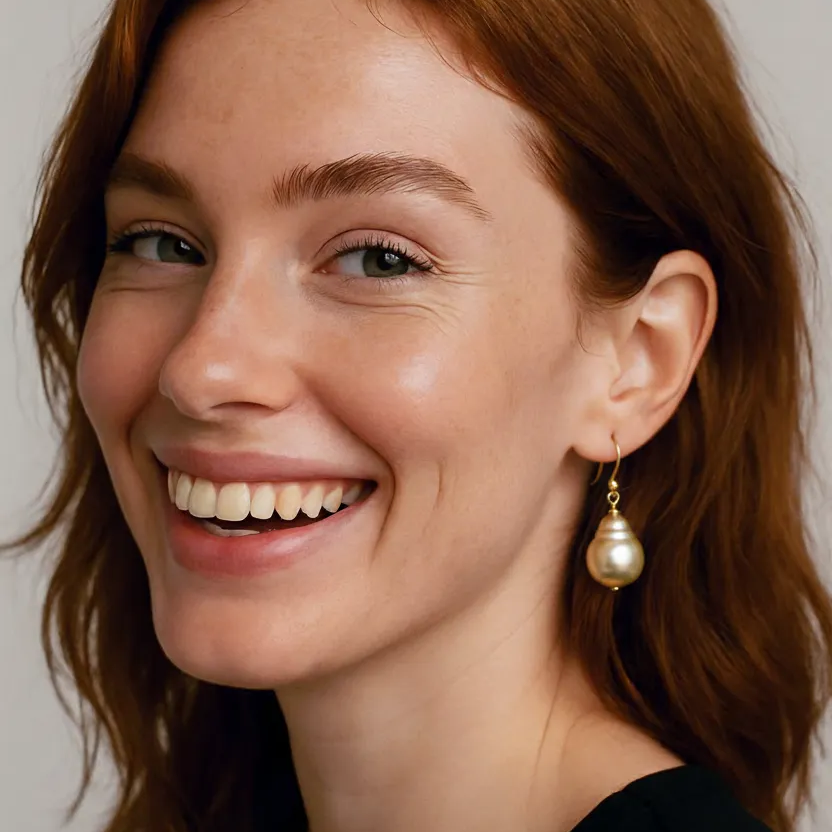 Woman with a smile wearing pearl earrings against a neutral background