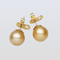 Gold pearl earrings on a light gray background
