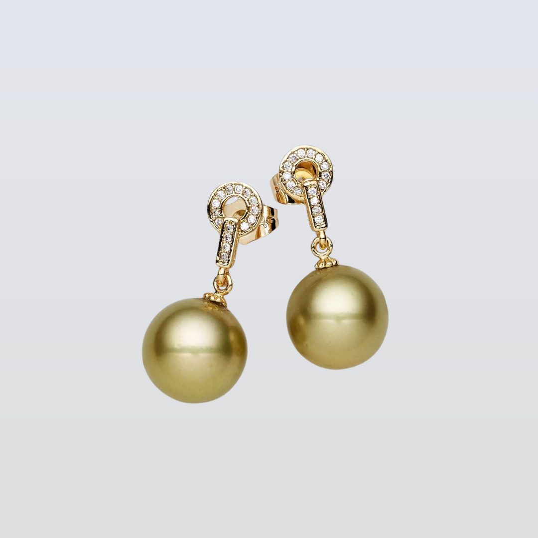 Gold pearl earrings on a light gray background