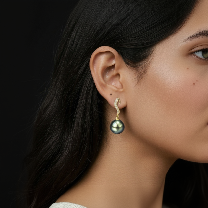 Pearl earring worn by a person with dark hair against a black background