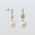 Pearl earrings with silver clasps on a light gray background