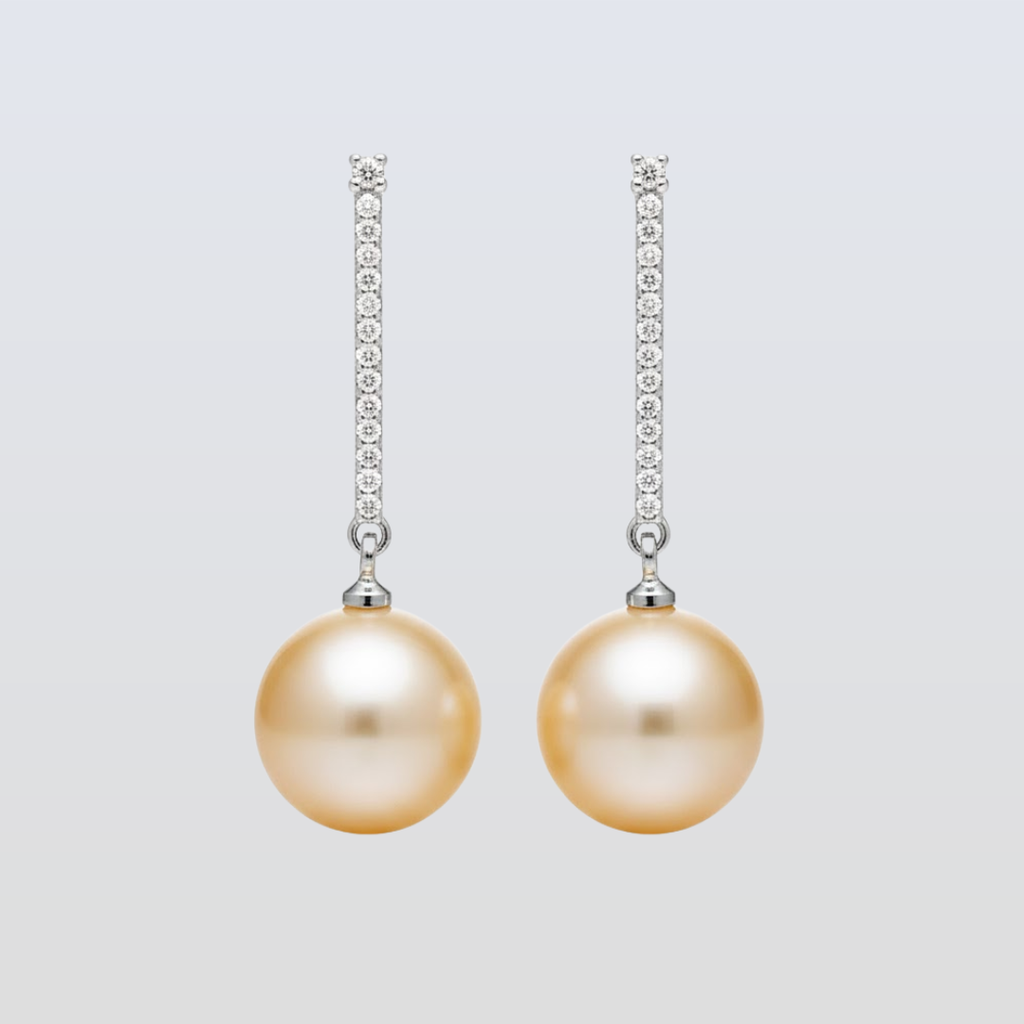 Pair of pearl earrings with diamond accents on a light gray background
